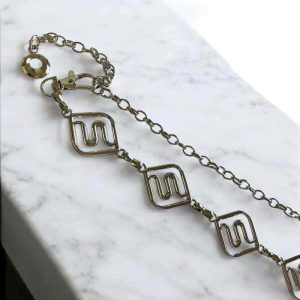 Cinto em metal prateado em curvas