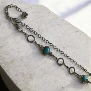 Cinto em metal prateado em circulos com esferas azuis