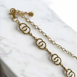 Cinto em metal dourado em curvas entrelaçadas