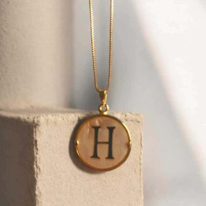 Colar com pingente em Madre pérola na letra H folheado à ouro